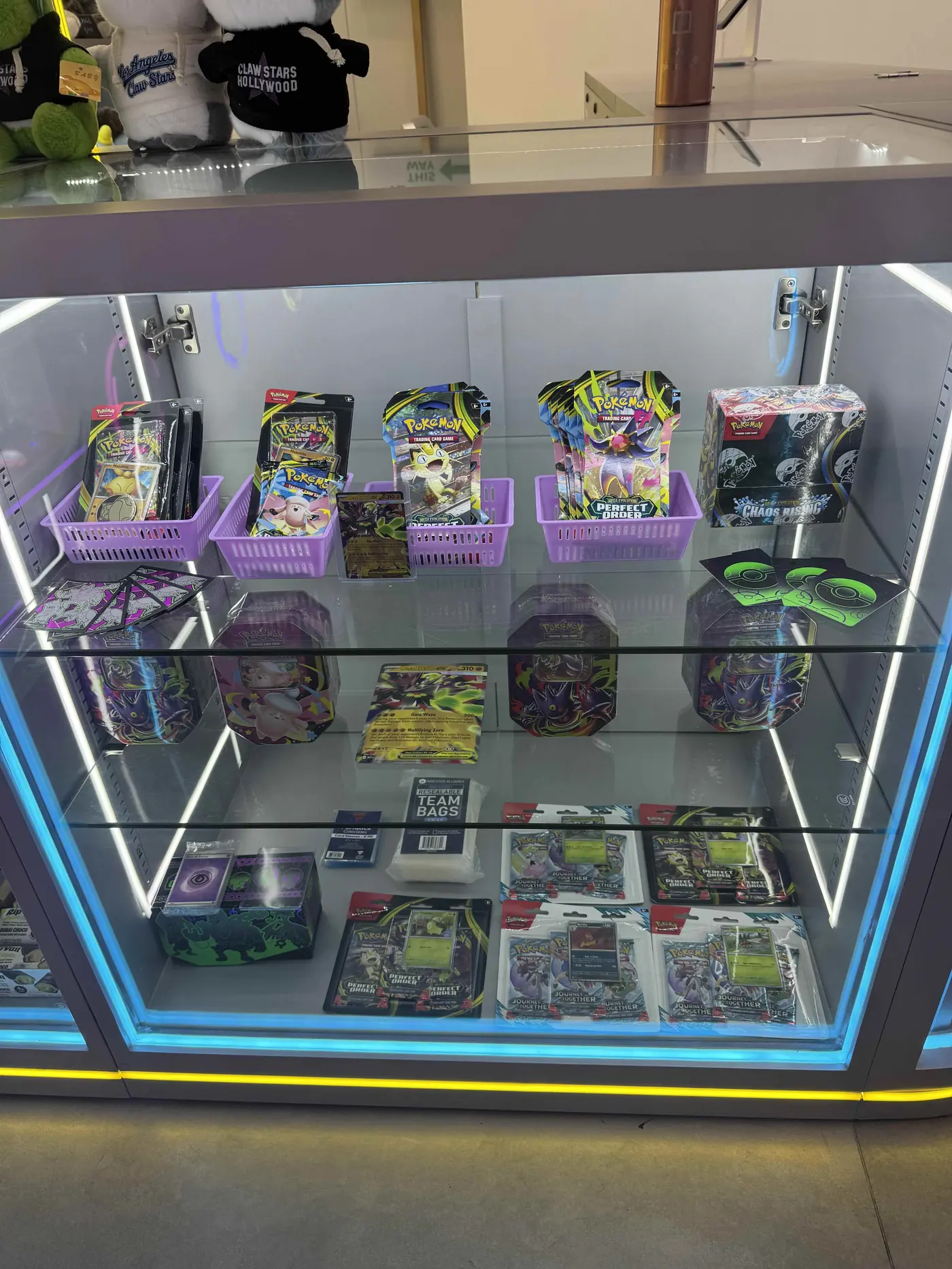 Pokemon booster packs, tins and sealed product in the Claw Stars display case