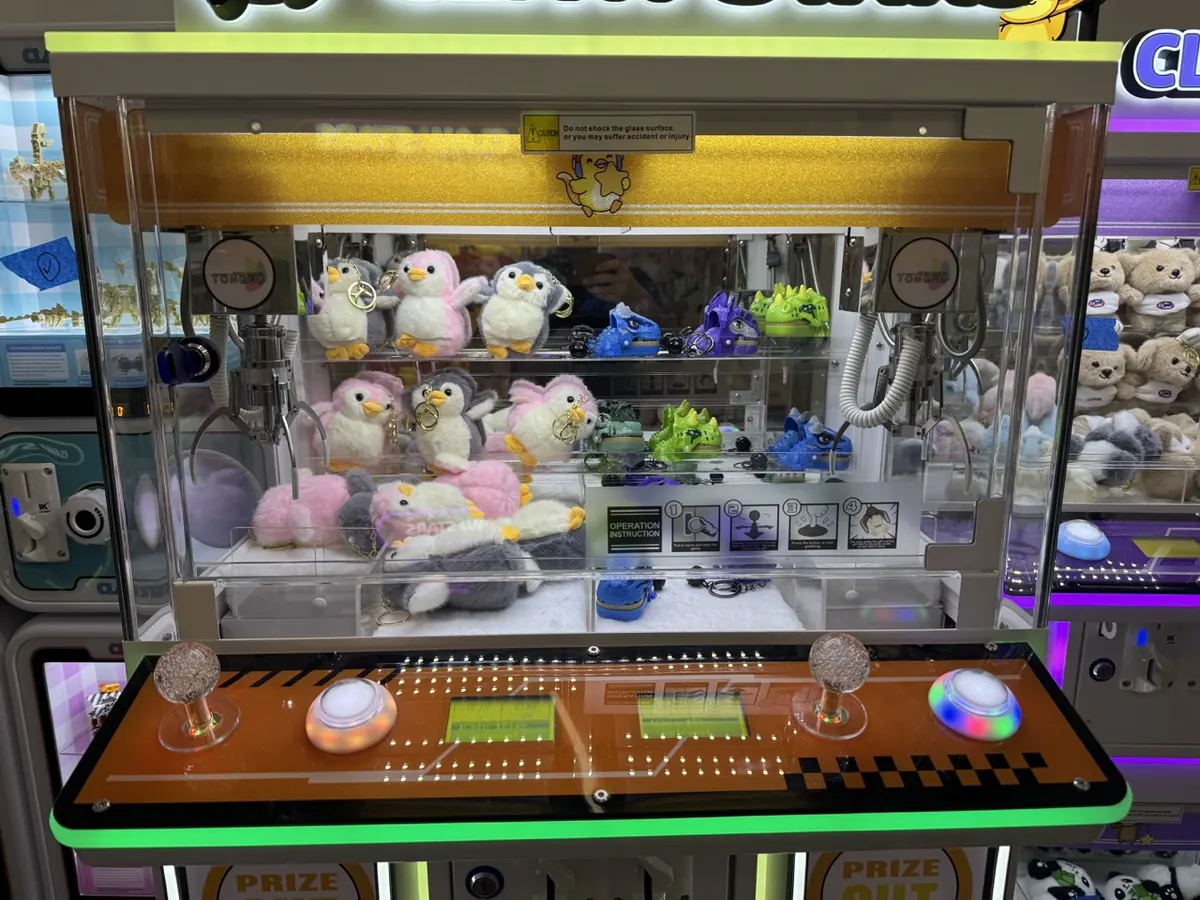 Penguin plushies lined up inside a Claw Stars machine